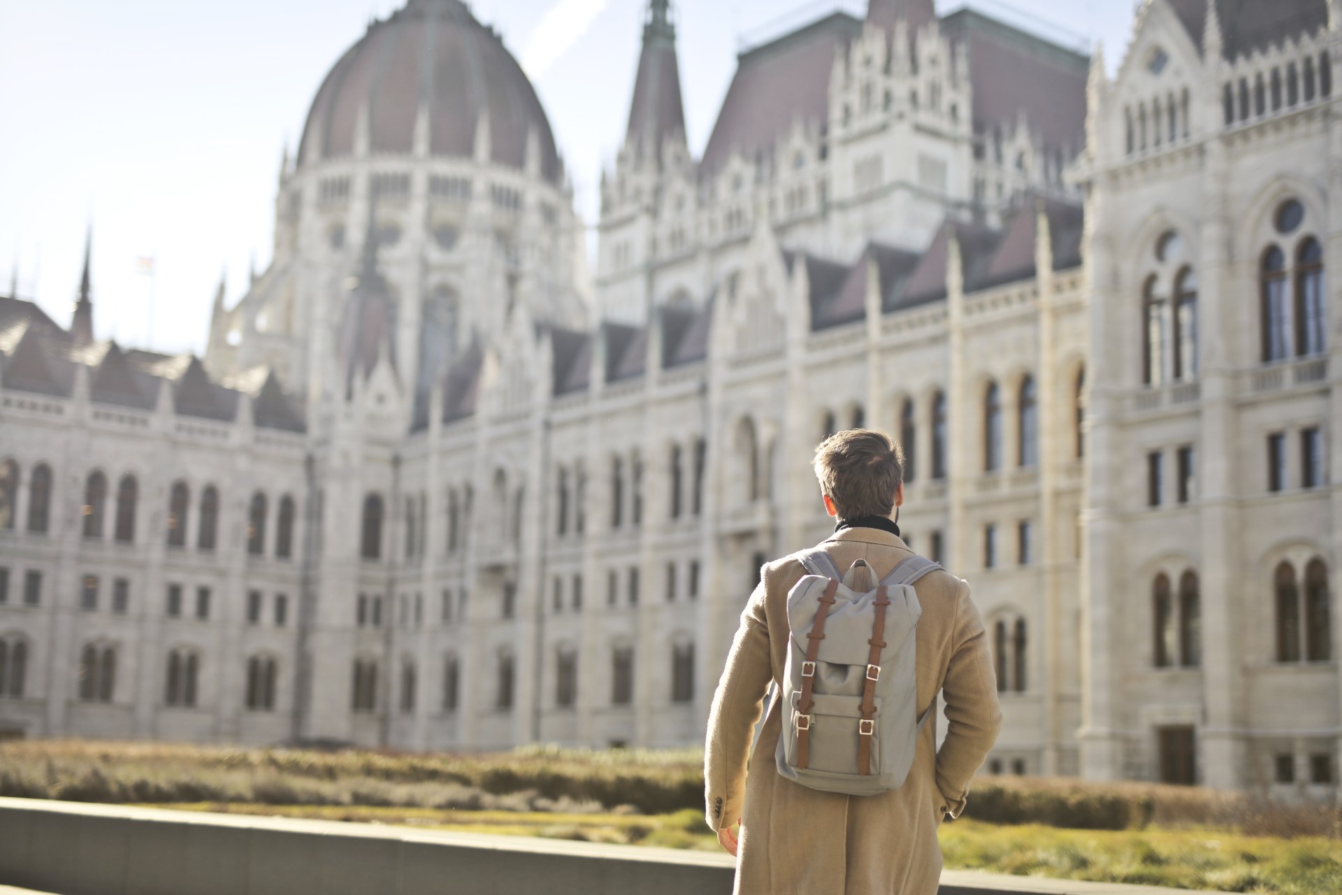 Jovem de mochila em frente ao edifício do Parlamento húngaro, em Budapeste