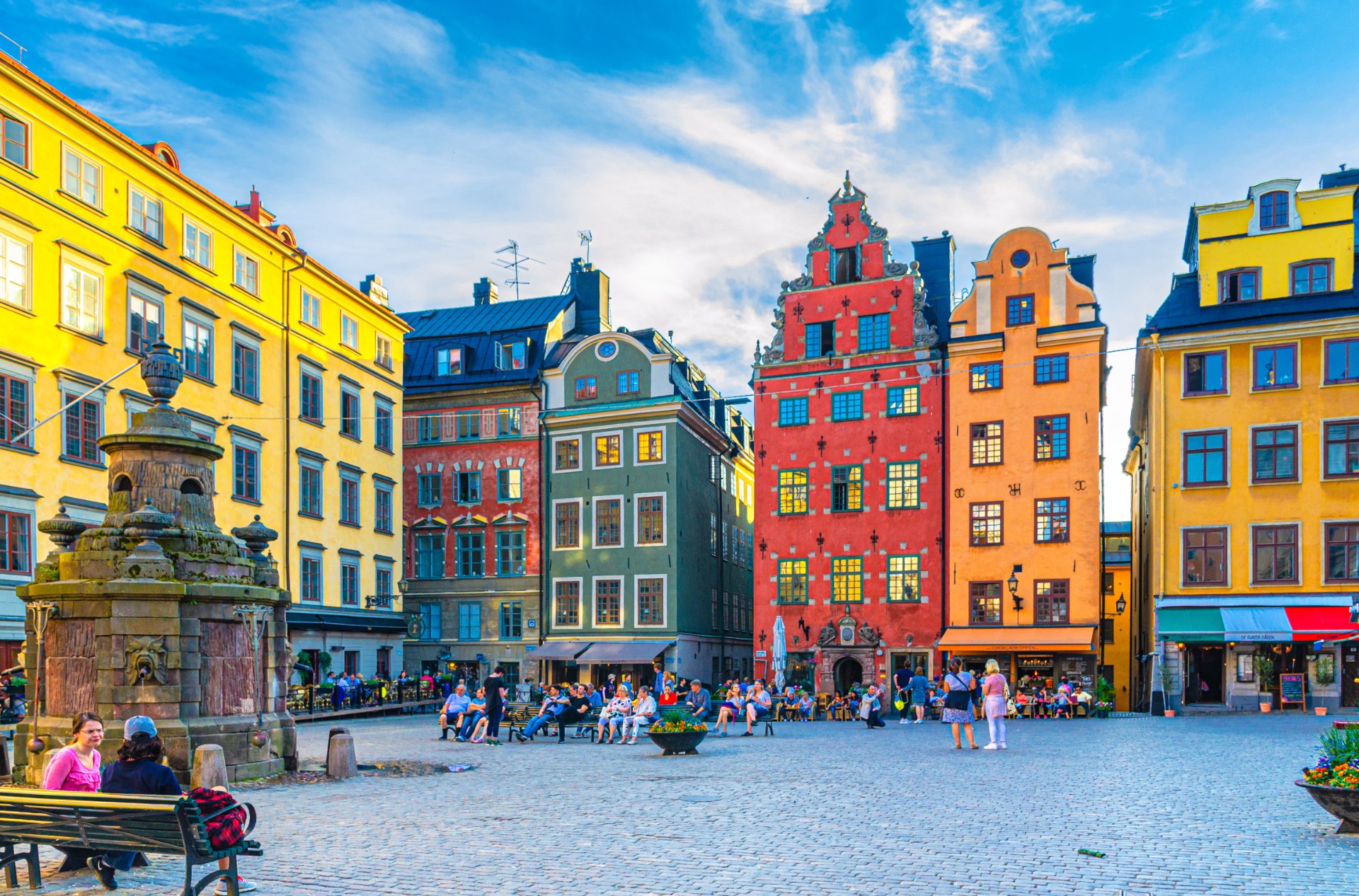 Turistas e transeuntes na praça Stortorget, em Estocolmo, entre casas coloridas
