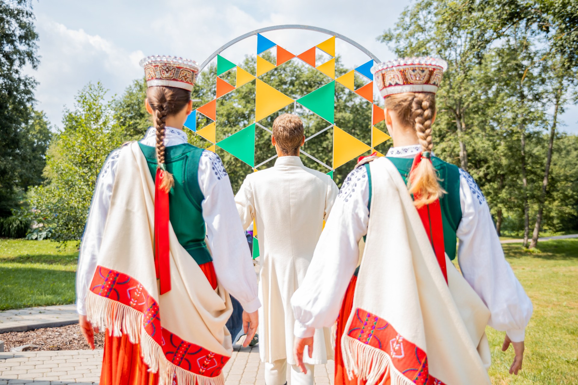 Jovens com trajes tradicionais letões no Festival da Canção e da Dança da Letónia