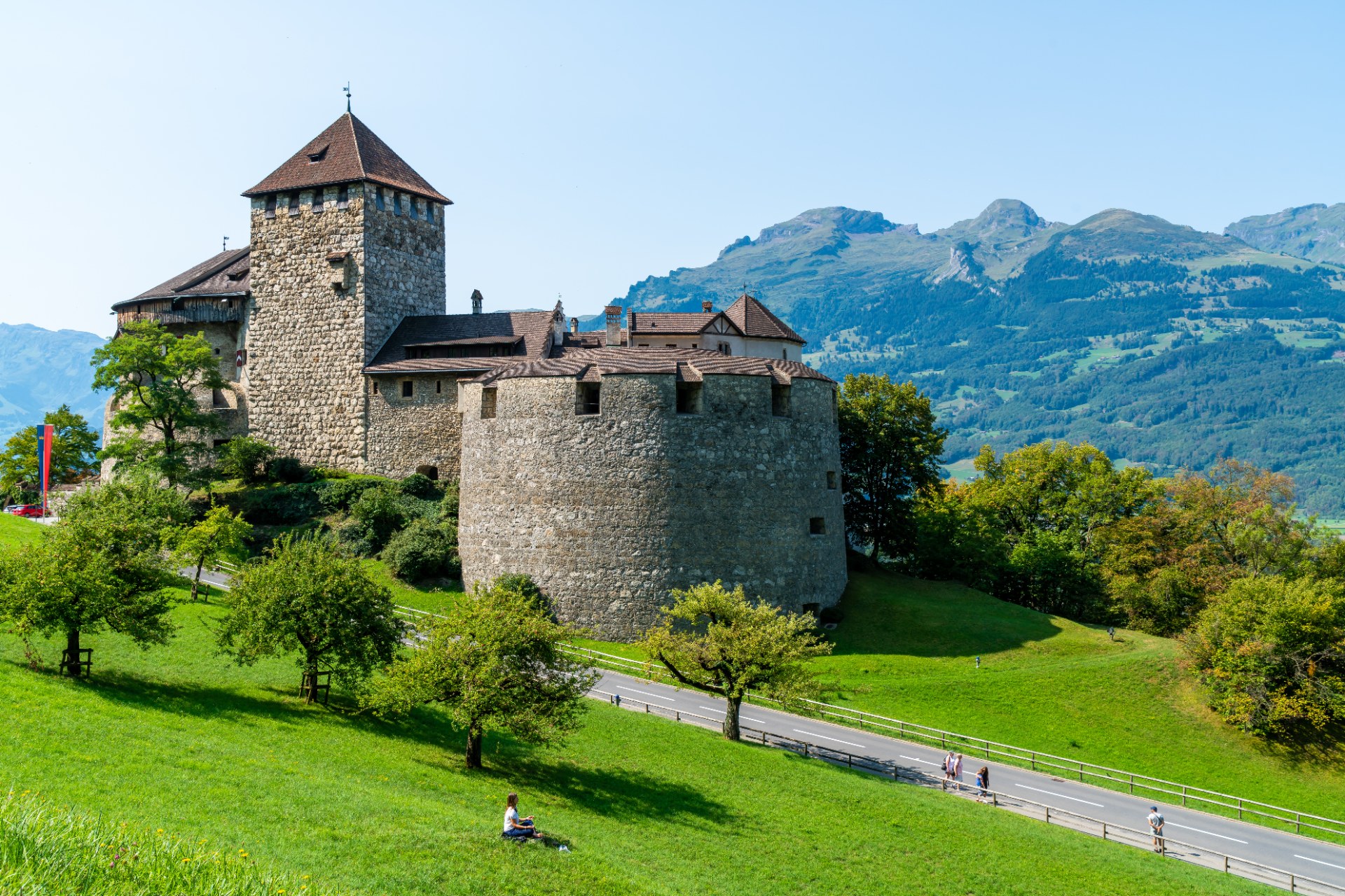 Castelo de Vaduz numa encosta verde, com as montanhas do Listenstaine ao fundo
